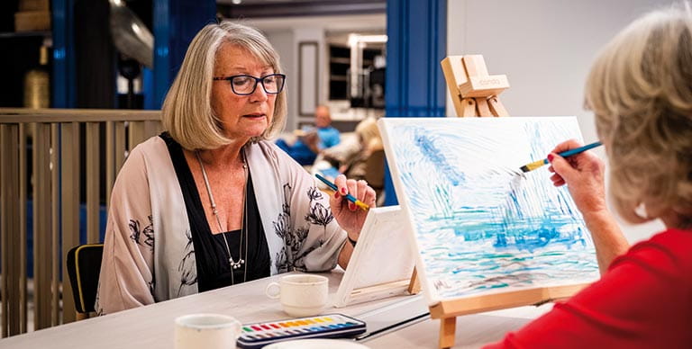 Two women painting in the Craft Room on Spirit of Adventure